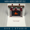 the inside of the warm wishes card is a pop up of a fireplace with a mantel with stockings and candles